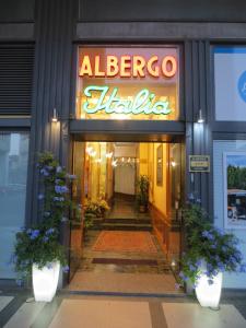 an entrance to a albergo libilia with a neon sign at Hotel Italia City Center in Mantova