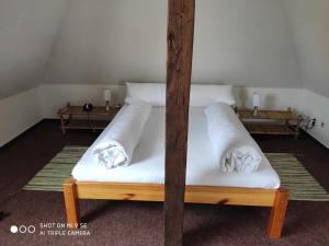 a bedroom with a bed with white sheets and pillows at Apartment unterm Dach in Wismar