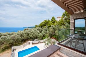 an ocean view from the balcony of a house with a swimming pool at Adria lux apartmens 2 in Sveti Stefan