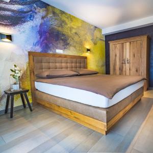 a bedroom with a bed and a painting on the wall at Le Manoir Vionnaz in Vionnaz
