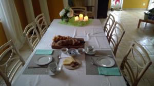 una mesa con mantel blanco, platos y velas en Bed and Breakfast 24, en Stein am Rhein