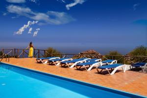 a woman standing on a deck next to a swimming pool at La Collina dei Nebrodi in San Marco dʼAlunzio