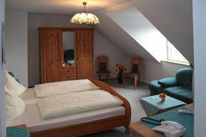 a bedroom with a bed and a living room with a couch at Pension & Gasthaus Kahren in Kahren