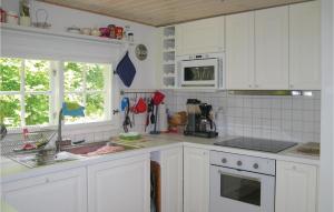 イースタッドにある2 Bedroom Lovely Home In Ystadのシンクと電子レンジを備えた白いキッチン