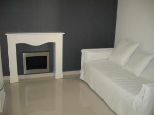 
a living room with a white couch and a fire place at Crystal Hotel in Kakopetria
