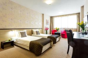a hotel room with two beds and a desk at City Avenue Hotel by HMG-Free Parking-Free Wi-Fi in Sofia