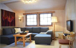 a living room with a blue couch and a table at Stunning Home In Eggedal With Kitchen in Eggedal