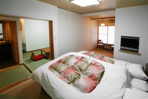 Postel nebo postele na pokoji v ubytování Masutomi Ryokan