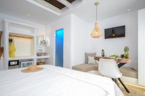 a white bedroom with a white bed and a white chair at Naxos Island Escape Suites in Plaka