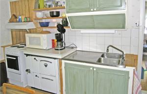 a small kitchen with a sink and a microwave at One-Bedroom Holiday Home In Unnaryd in Sunnaryd