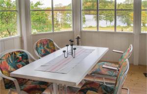 uma mesa branca e cadeiras com janelas num quarto em Nice Home In Korsberga With Kitchen em Korsberga