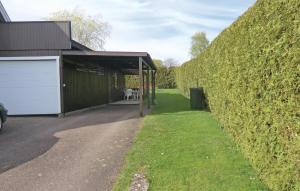 a garage next to a hedge with a building at 2 Bedroom Gorgeous Home In Borgholm in Borgholm