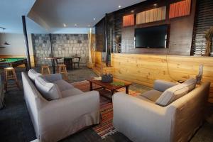 a living room with couches and a flat screen tv at Colorado Apart Hotel in El Colorado