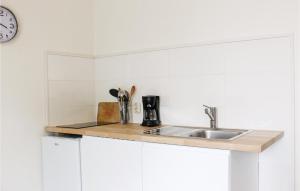 a kitchen counter with a sink and a clock at Appartement 1 - De Eekhof in Hindeloopen