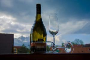 a bottle of wine sitting next to a glass at Privát Harenčár in Stará Lesná