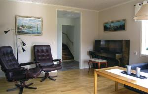 uma sala de estar com duas cadeiras e um piano em Amazing Home In Tranemo With Kitchen em Tranemo