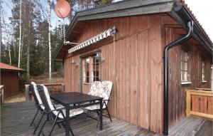 a wooden cabin with a table and chairs on a deck at Beautiful Home In rjng With 3 Bedrooms And Wifi in Årjäng