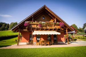 a house with a balcony with tables and flowers at Penzion Major in Rokytnice nad Jizerou