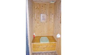 uma pequena casa de banho com um WC verde numa parede de madeira em Sjboda em Barnebo