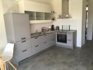 a kitchen with white cabinets and a sink at Klause am grünen Hof in Friesoythe