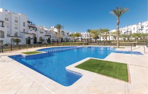 a swimming pool in a apartment with palm trees and buildings at 2 Bedroom Amazing Apartment In Roldán in Los Tomases
