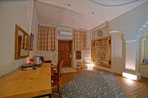 a living room with a wooden table and a desk at Taru Cave Suites in Urgup