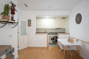 a kitchen with white cabinets and a table and a counter at Pension Venecia Gomerez in Granada