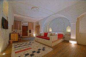 a bedroom with a bed and a couch in a room at Taru Cave Suites in Urgup
