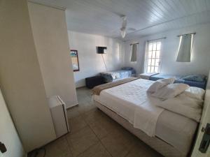 Un dormitorio con una cama grande y una ventana. en Canema Pousada, en Arraial do Cabo