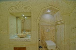 a bathroom with a sink and a toilet and a mirror at Taru Cave Suites in Urgup