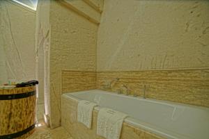 a bathroom with a bath tub with towels on it at Taru Cave Suites in Urgup