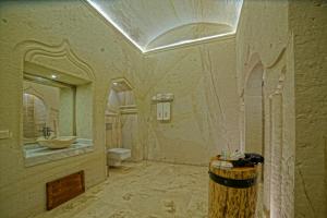 a large bathroom with a sink and a toilet at Taru Cave Suites in Urgup
