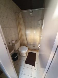 Un baño pequeño con inodoro y lavabo. en Canema Pousada, en Arraial do Cabo