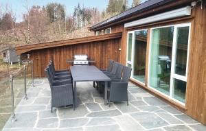 a patio with a table and chairs in front of a building at Four-Bedroom Holiday Home Farsund With Sea View 09 in Farsund