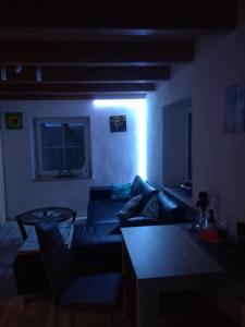 ein dunkles Wohnzimmer mit einem Sofa und einem Tisch in der Unterkunft Sonnige Zimmer in Eberhardzell