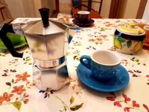 eine Kaffeemaschine und eine Tasse auf dem Tisch in der Unterkunft Alexis Home in Neapel