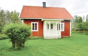 uma casa vermelha e branca com uma árvore no quintal em Stunning Home In Blomstermla With Kitchen em Barnebo