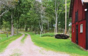 a dirt road next to a red barn at Holiday Home Hagen Barnebo Blomstermåla in Barnebo