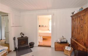 a living room with a wood stove and a bedroom at 2 Bedroom Stunning Home In Strömstad in Lommeland