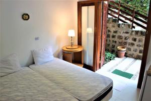 um quarto com uma cama e uma porta para uma varanda em Villa Félix Suites e Chalés em Ubatuba