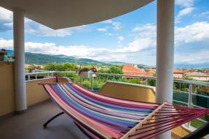 a hammock on a balcony with a view at Guest House Holiday in Ognyanovo