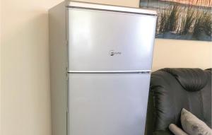 einen Kühlschrank in einem Zimmer neben einer Couch in der Unterkunft Nice Apartment In Insel Poel-gollwitz With 1 Bedrooms in Gollwitz