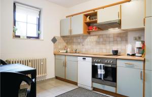 a kitchen with white cabinets and a stove top oven at 1 Bedroom Cozy Apartment In Schnecken in Schönecken