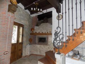 a living room with a staircase and a fireplace at Casa Rural Generoso in Madroñal