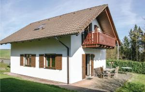 Dieses weiße Haus verfügt über einen Balkon und einen Tisch. in der Unterkunft Ferienhaus 26 In Kirchheim in Kirchheim
