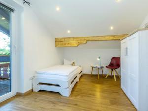 ein Schlafzimmer mit einem Bett und einem roten Stuhl in der Unterkunft Ferienwohnung Auszeit in Grassau