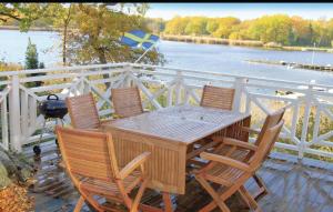 una mesa de madera y sillas sentadas en una terraza junto al agua en Nice Home In Ronneby With House Sea View, en Ronneby