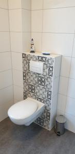 a bathroom with a toilet in a tiled wall at Ferienwohnung Muldental in Grimma