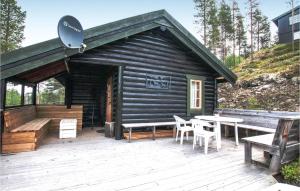 a log cabin with a table and chairs on a deck at 4 Bedroom Stunning Home In Rendalen in Rendalen +10 photos