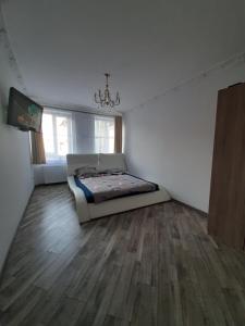 a bedroom with a bed and a wooden floor at Apartment in Serbska Lviv in Lviv